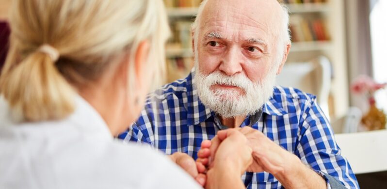 Image of woman holding elderly man's hand